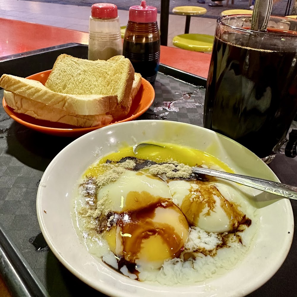 Soft-boiled eggs with toast and kopi O on a tray, the classic Seng Kee breakfast